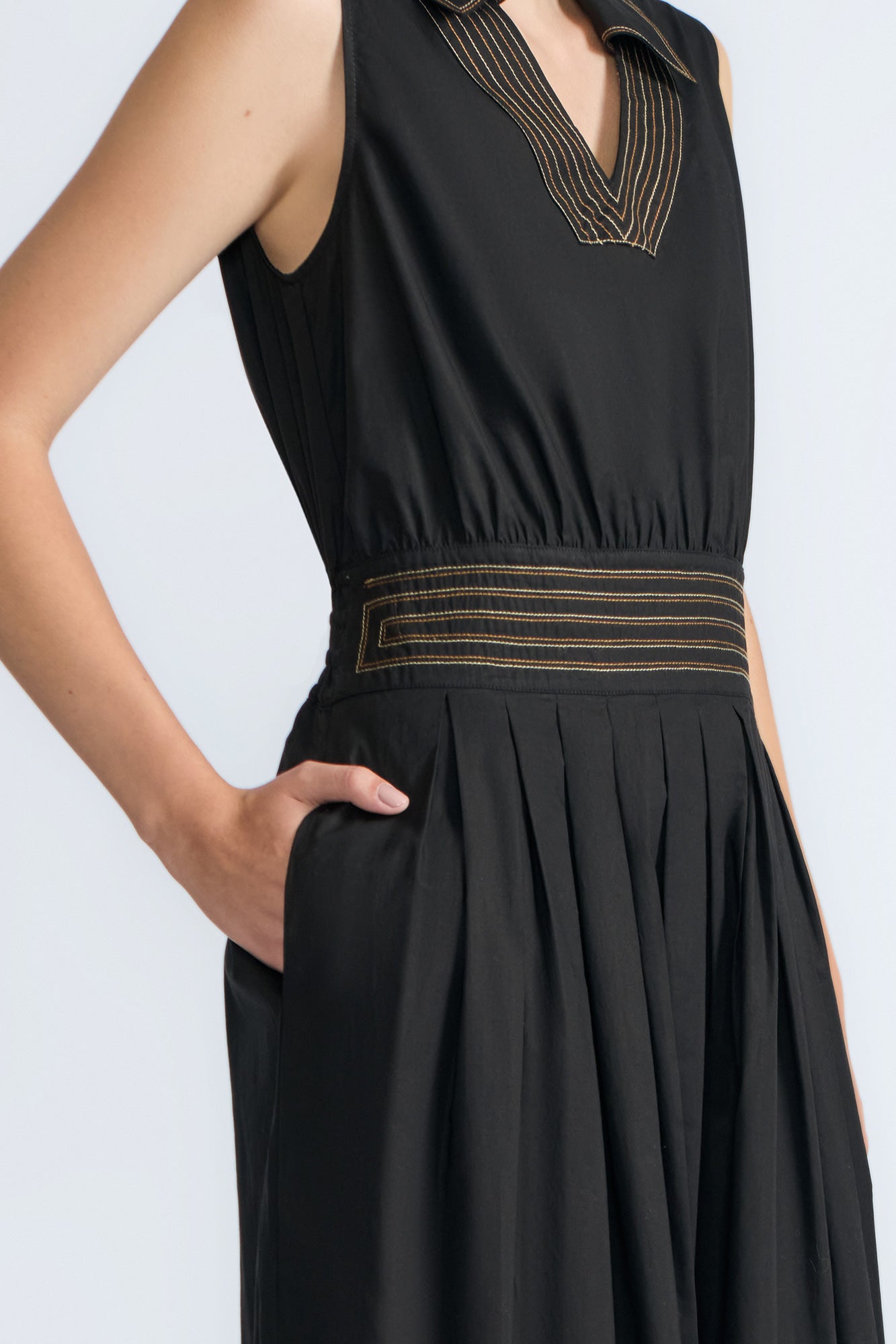 Isidora Dress in Black – Sleeveless midi cotton dress with shirt collar V-neckline, tiered silhouette, and hidden side pockets.
