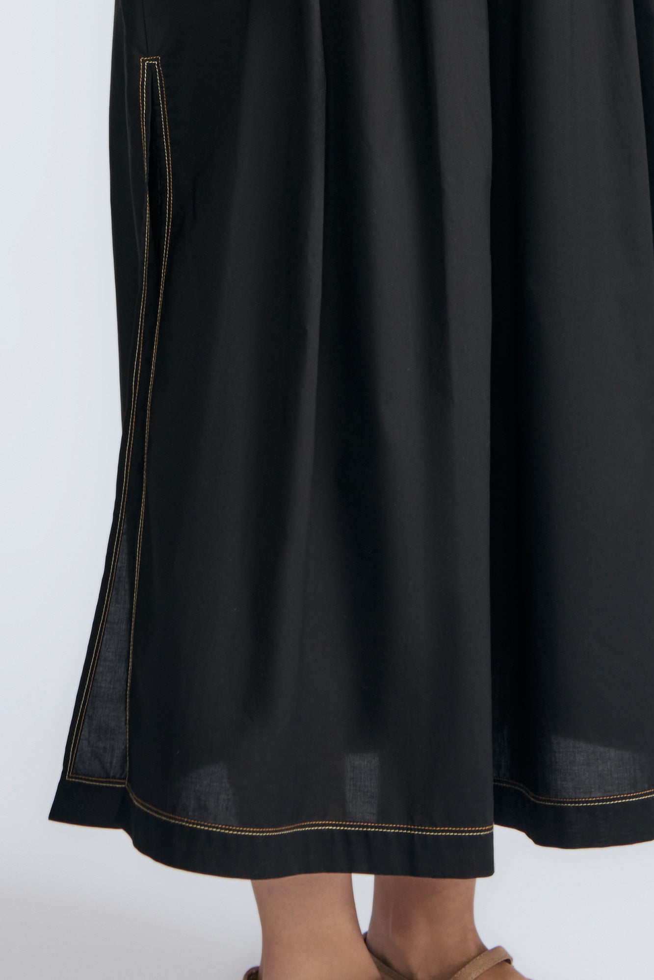 Isidora Dress in Black – Sleeveless midi cotton dress with shirt collar V-neckline, tiered silhouette, and hidden side pockets.