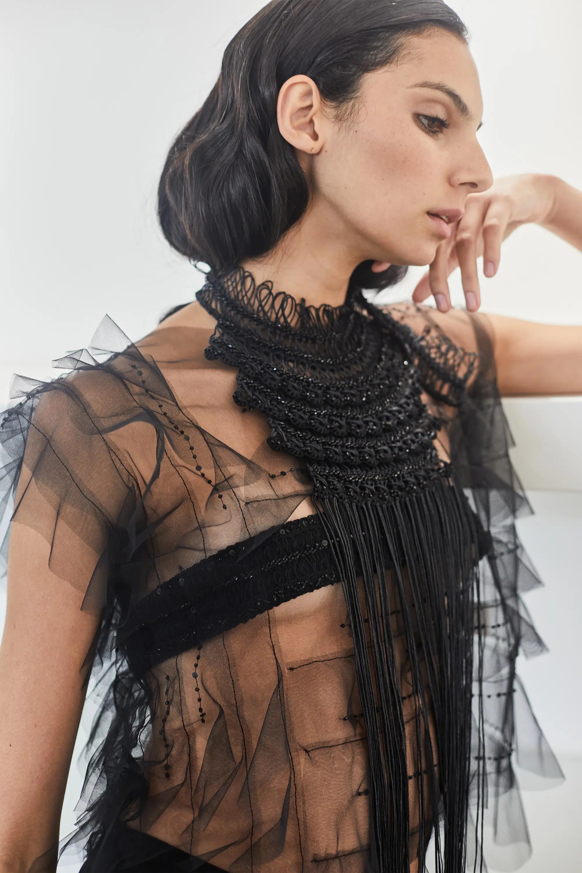 A close-up of the Lara Peto in Black, highlighting the hand-embroidery of beads and crystals on the macrame.