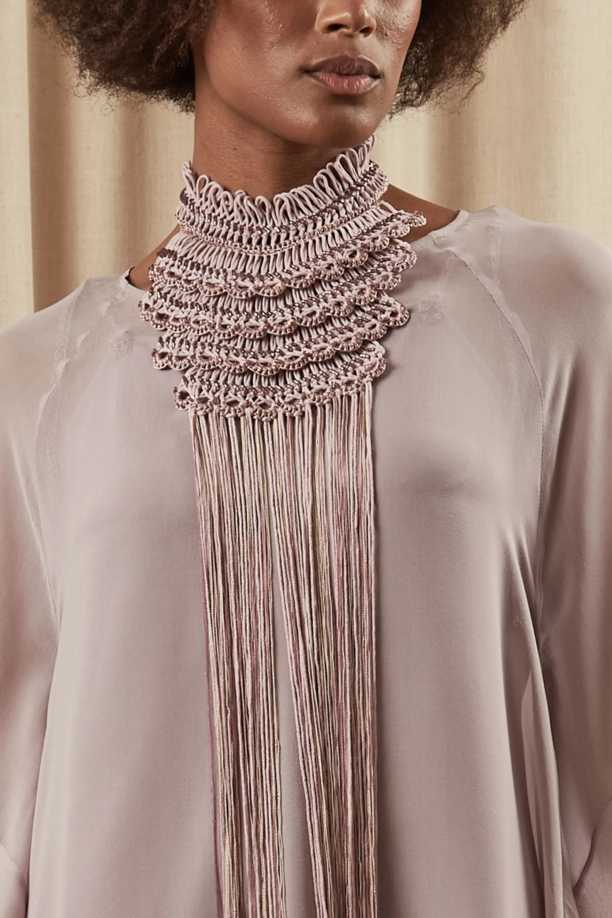 A close-up of the Lara Peto in Rose, highlighting the hand-embroidery of beads and crystals on the macrame.