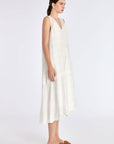 The Off White Lenox Dress shown in profile, highlighting the flared godet skirt.