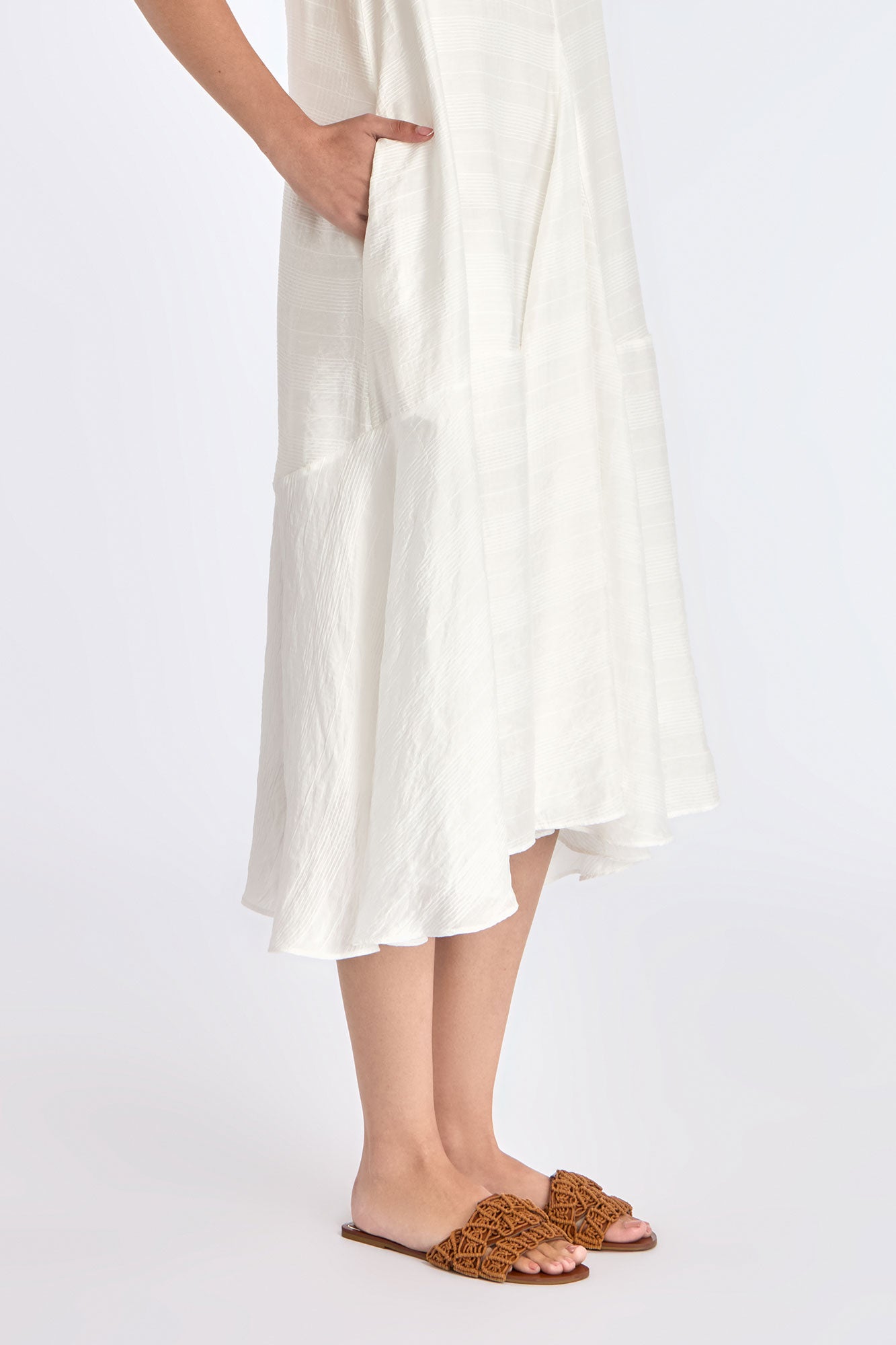 Close-up on the woven texture and godet panel seam of the Off White Lenox Dress.