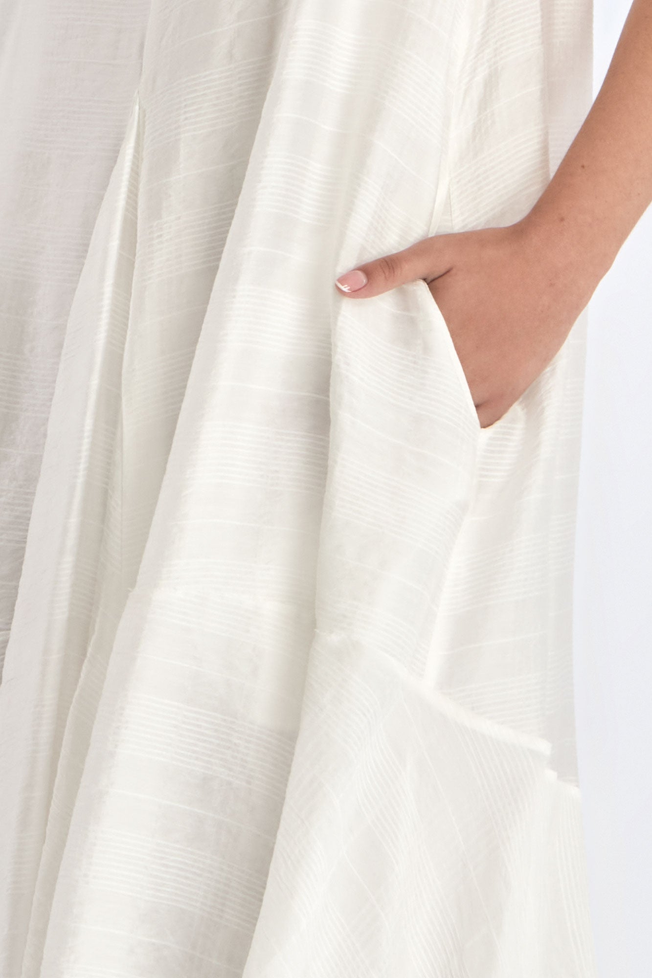 Close-up on the woven texture and godet panel seam of the Off White Lenox Dress.