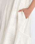 Close-up on the woven texture and godet panel seam of the Off White Lenox Dress.