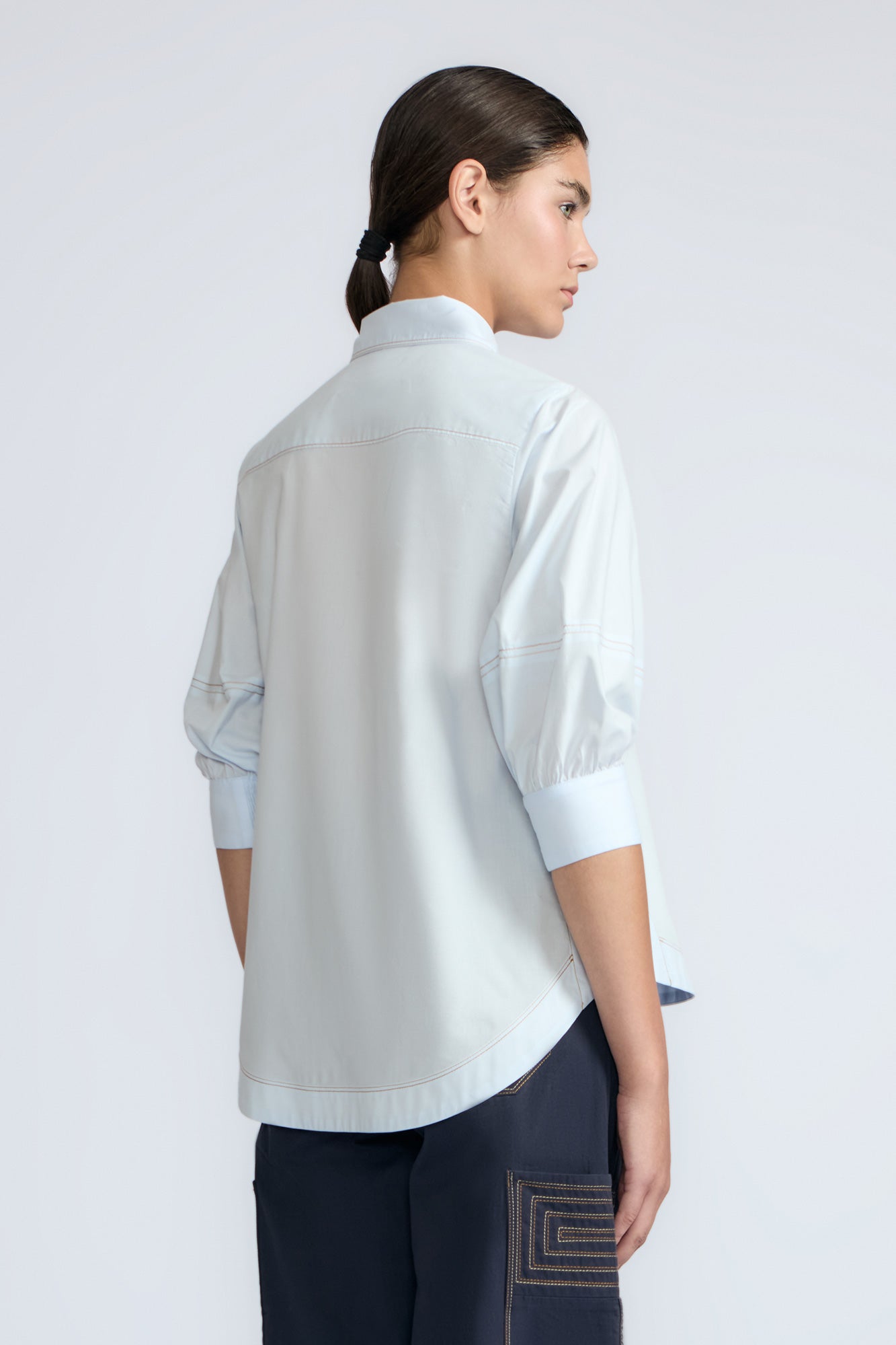 Lina Blouse in Light Blue – Cotton shirt with shirt collar, hidden button closure, ¾ balloon sleeves, and elastic cuffs.