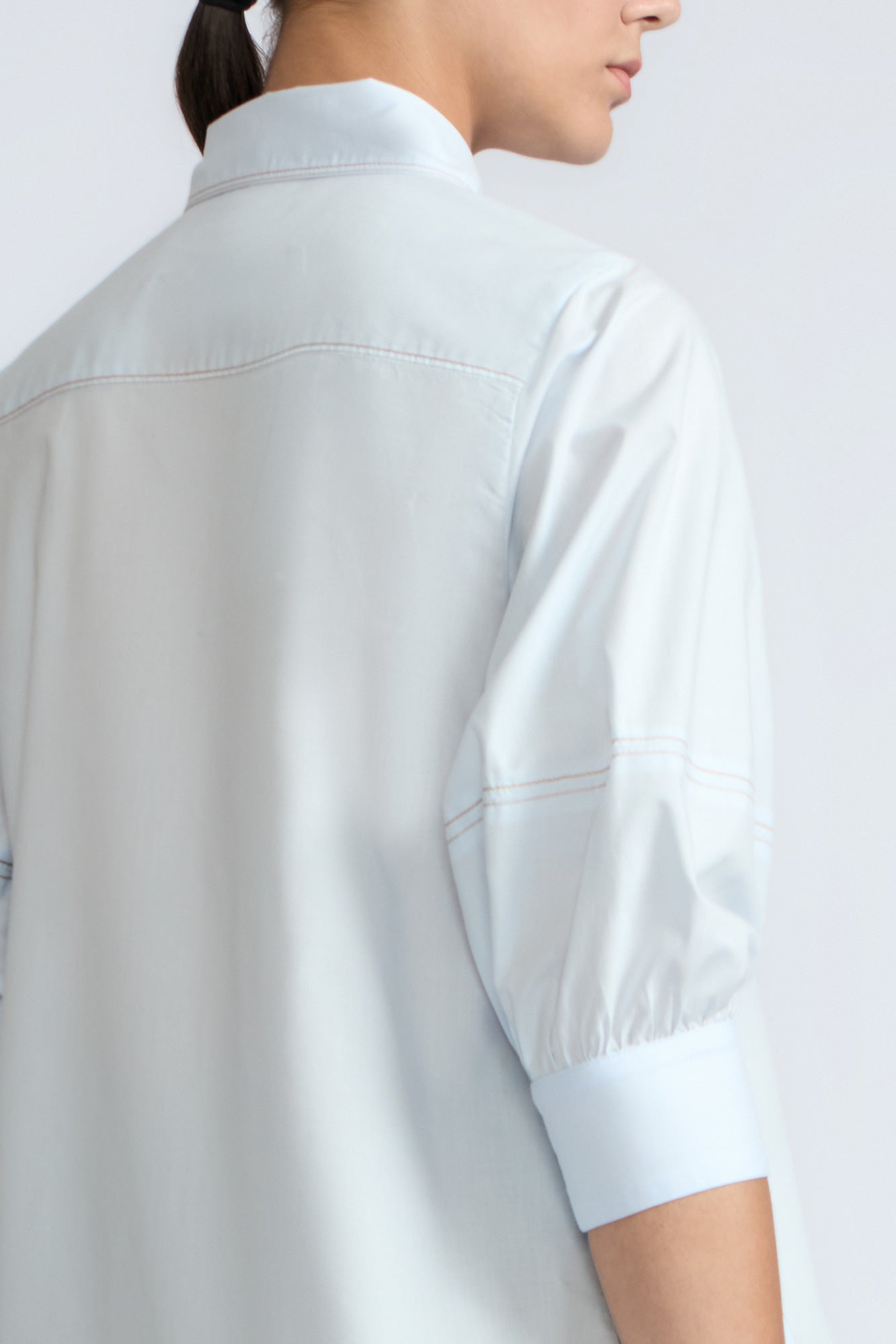 Lina Blouse in Light Blue – Cotton shirt with shirt collar, hidden button closure, ¾ balloon sleeves, and elastic cuffs.