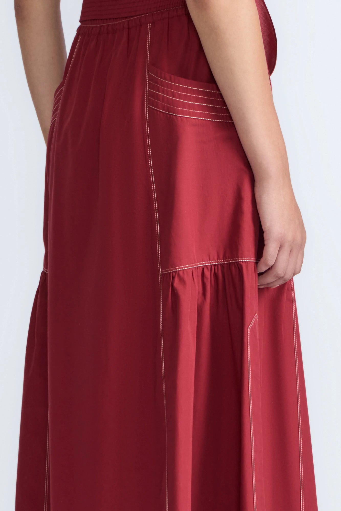 Close-up of the artisanal contrast stitching on the wine cotton Milena Skirt.