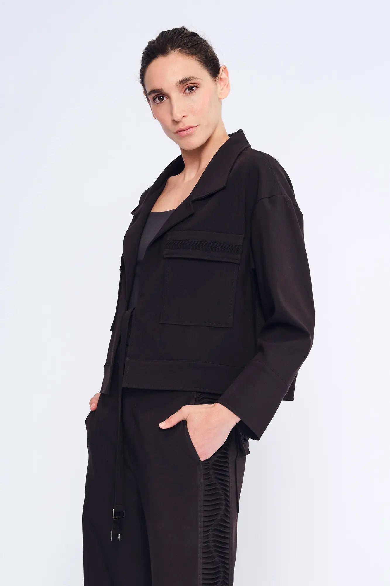 Side view of the black Parker Jacket, showcasing its modern, waist-length cut.