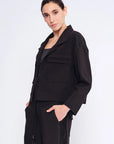 Side view of the black Parker Jacket, showcasing its modern, waist-length cut.