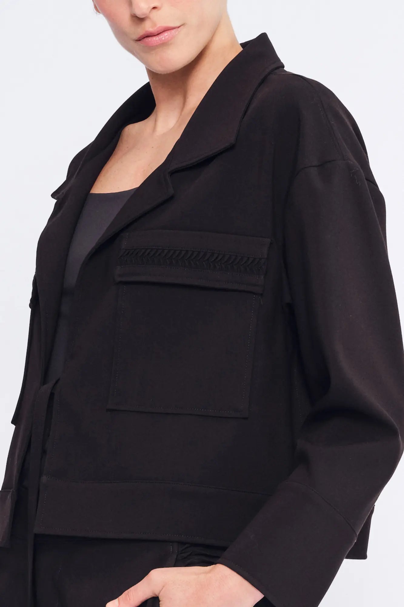 Detail shot of the tonal, raised gathered texture on the flap pocket of the black Parker Jacket.