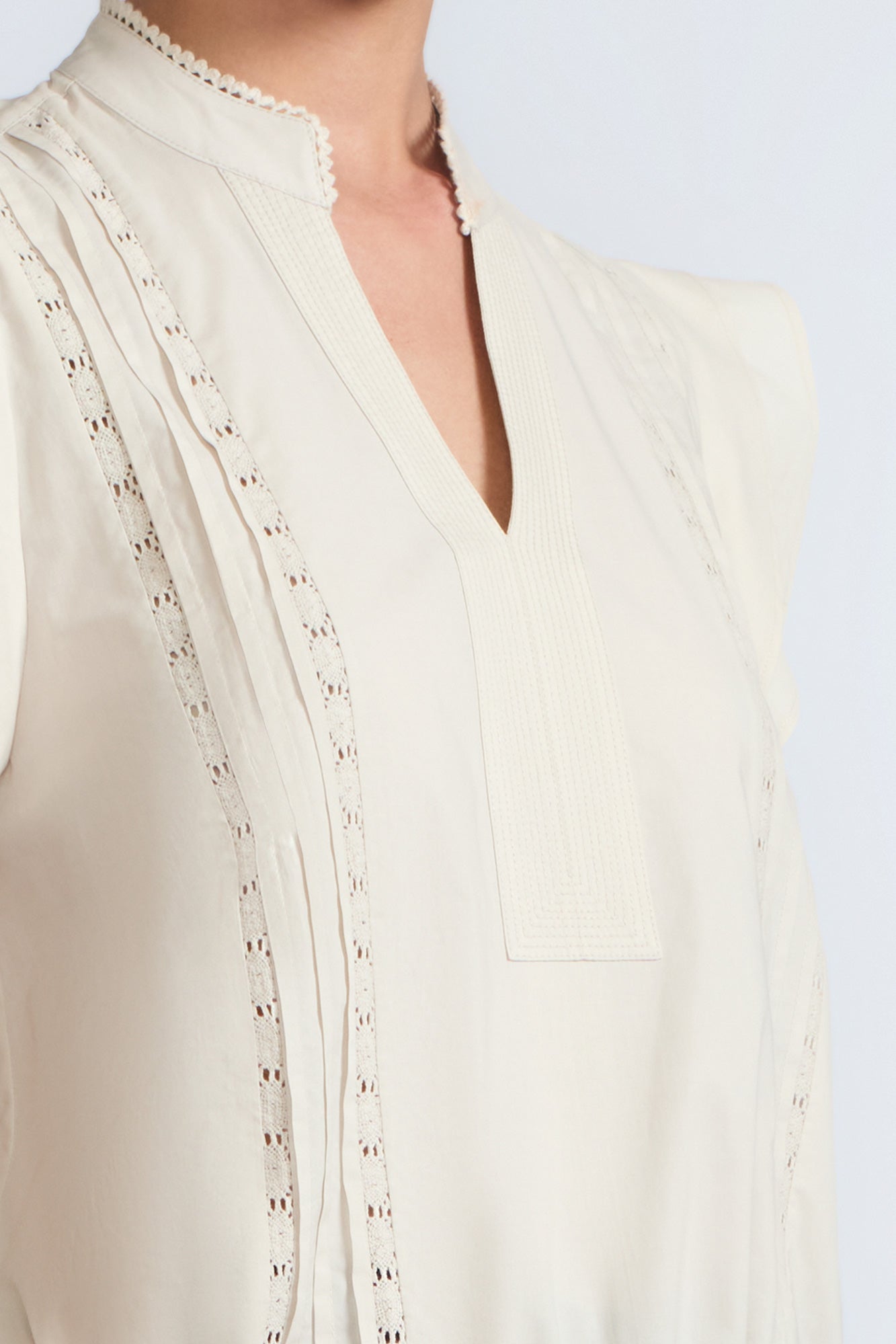 Pria Blouse in Prestine – Elegant sleeveless blouse in pima cotton with tonal V-neck, Greca trim, ruffle detail, and hem with pullers.