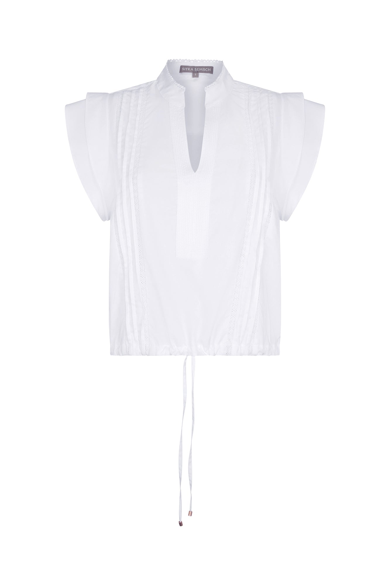 Pria Blouse in White – Sleeveless pima cotton blouse with V-neckline, Greca trim, tonal stitching, ruffle sleeves, and hem pullers.