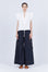 Pria Blouse in White – Sleeveless pima cotton blouse with V-neckline, Greca trim, tonal stitching, ruffle sleeves, and hem pullers.