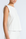White sleeveless top worn by a person on a plain background