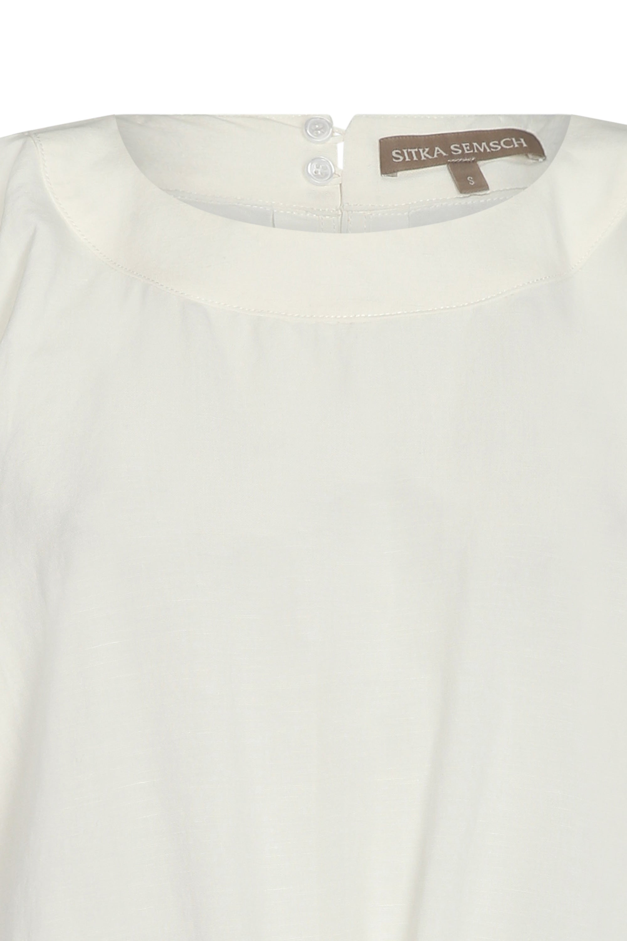 Shelby Blouse in Off White with a round neck, button-back detail, elasticated short sleeves, and flattering tie hem.