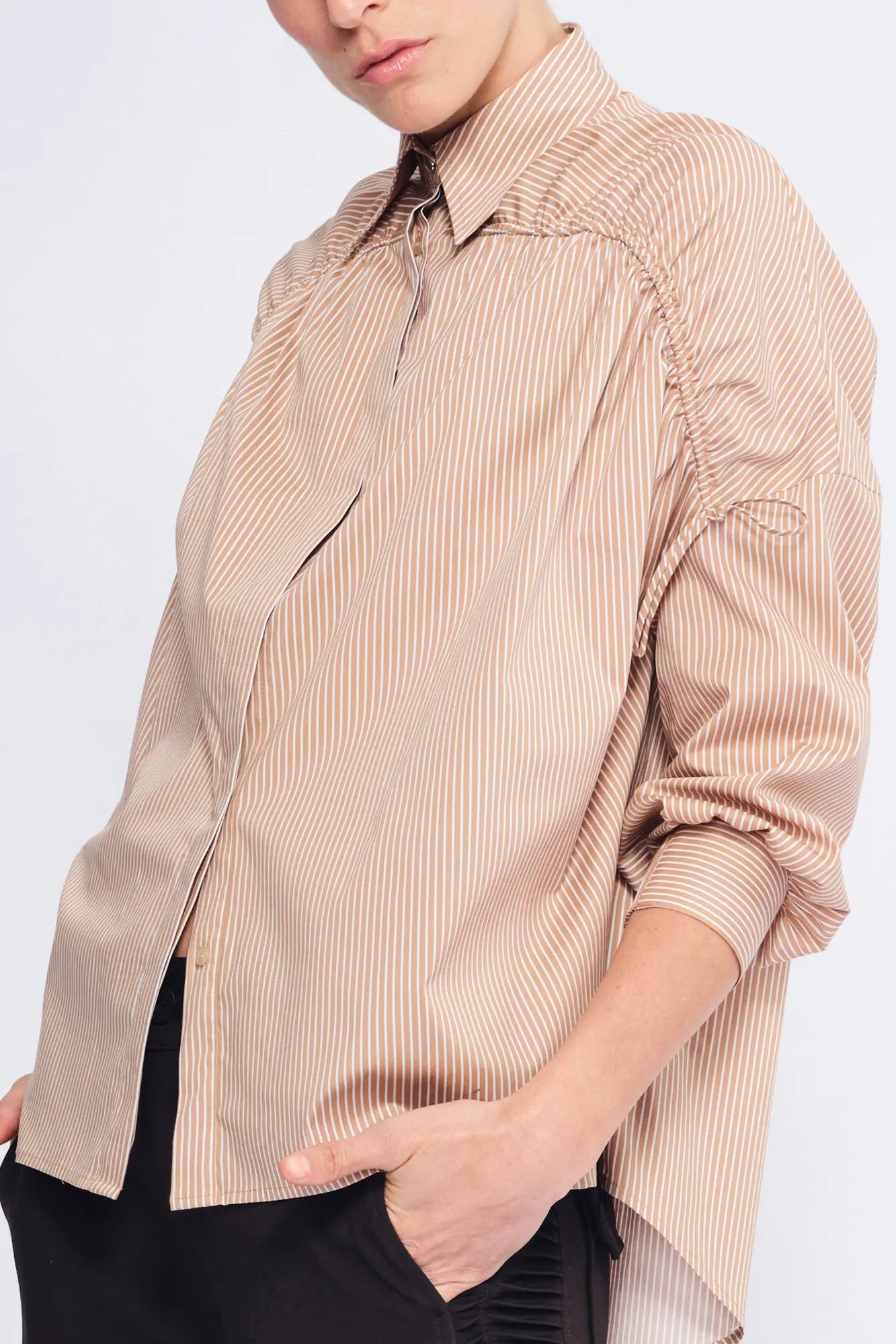 Detail shot of the adjustable drawstring on the shoulder, a signature of the Camel Star Blouse&#39;s transformative design.
