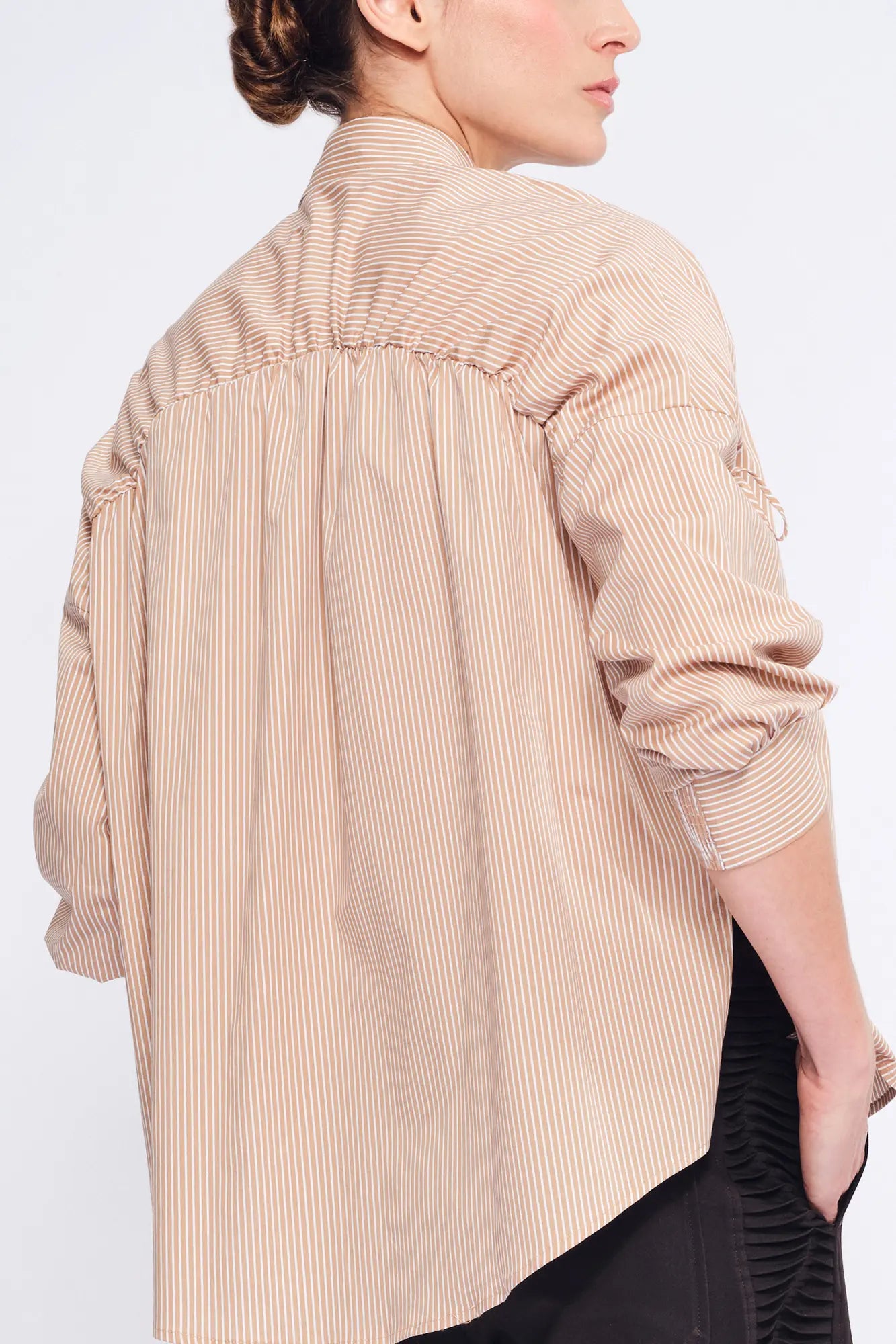 Detail shot of the adjustable drawstring on the shoulder, a signature of the Camel Star Blouse&#39;s transformative design.