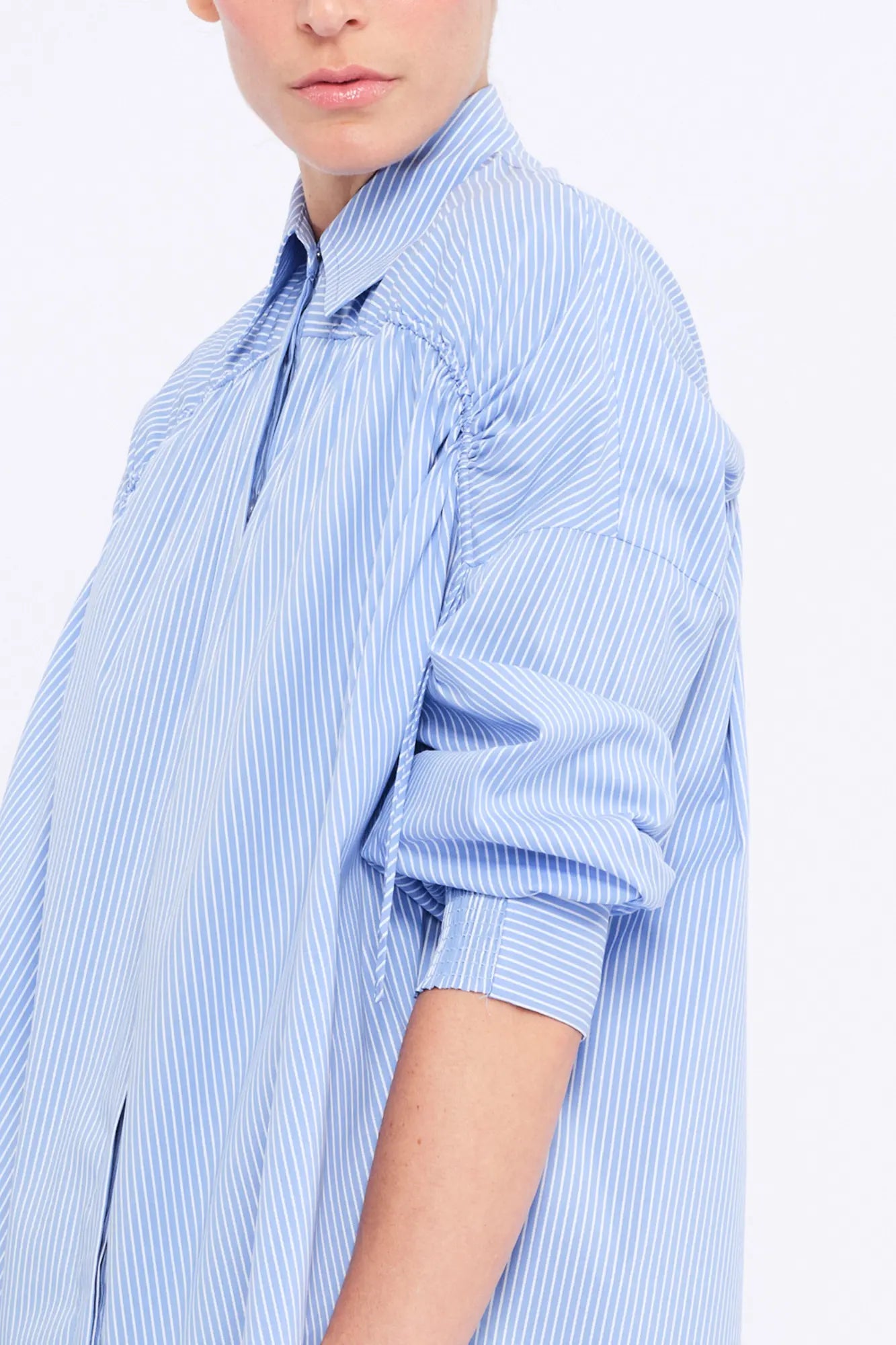 Close-up of the innovative drawstring that defines the shoulder of the Light Blue Star Blouse.
