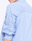 Close-up of the innovative drawstring that defines the shoulder of the Light Blue Star Blouse.