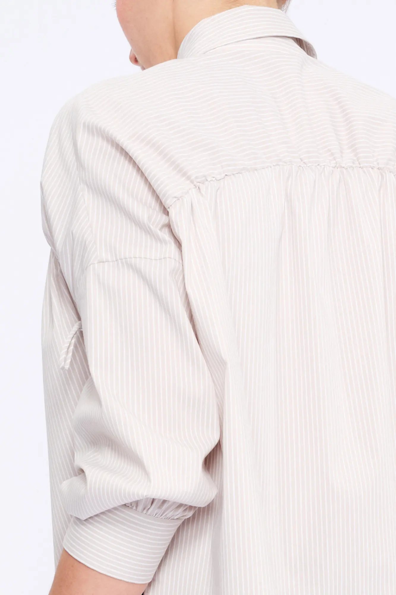Close-up of the innovative drawstring mechanism on the shoulder of the Sand Star Blouse, a detail of considered design.