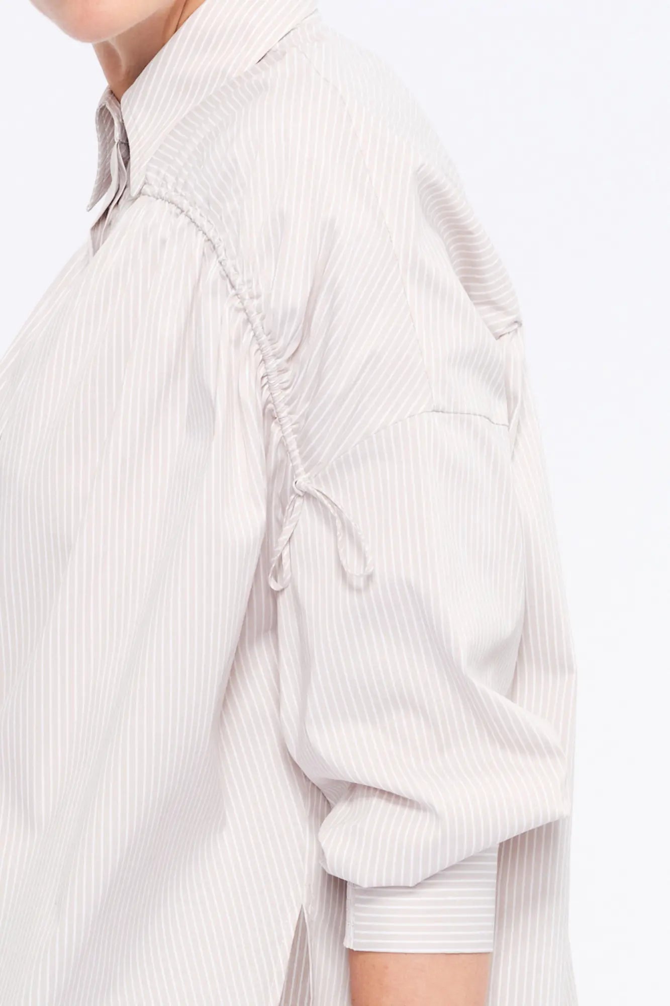 Close-up of the innovative drawstring mechanism on the shoulder of the Sand Star Blouse, a detail of considered design.