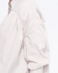 Close-up of the innovative drawstring mechanism on the shoulder of the Sand Star Blouse, a detail of considered design.