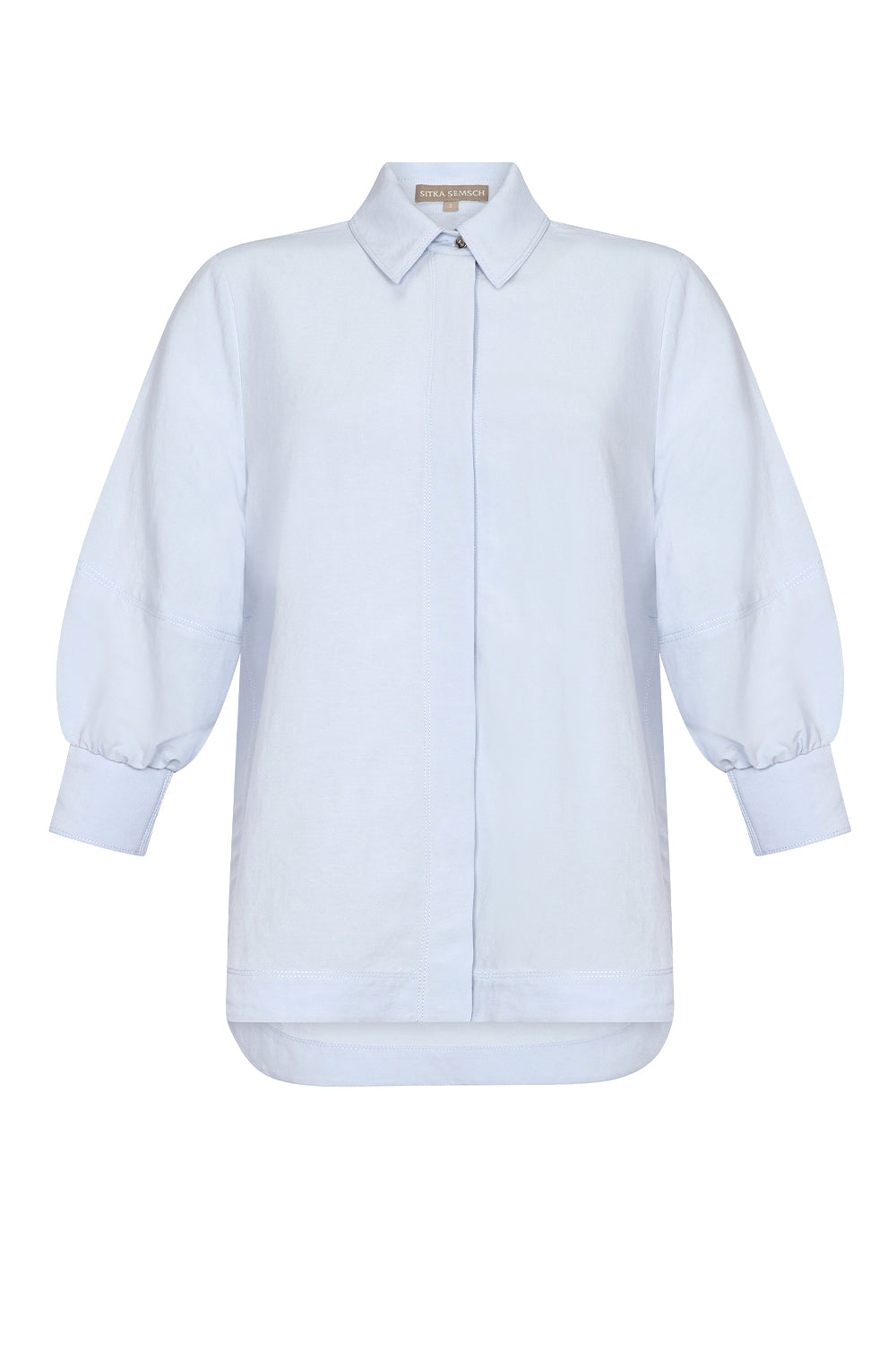 Tatiana Blouse in Sky showcasing a sophisticated shirt collar, concealed button placket, and romantic puff sleeves.