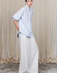 Tatiana Blouse in Sky showcasing a sophisticated shirt collar, concealed button placket, and romantic puff sleeves.