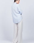 Tatiana Blouse in Sky showcasing a sophisticated shirt collar, concealed button placket, and romantic puff sleeves.