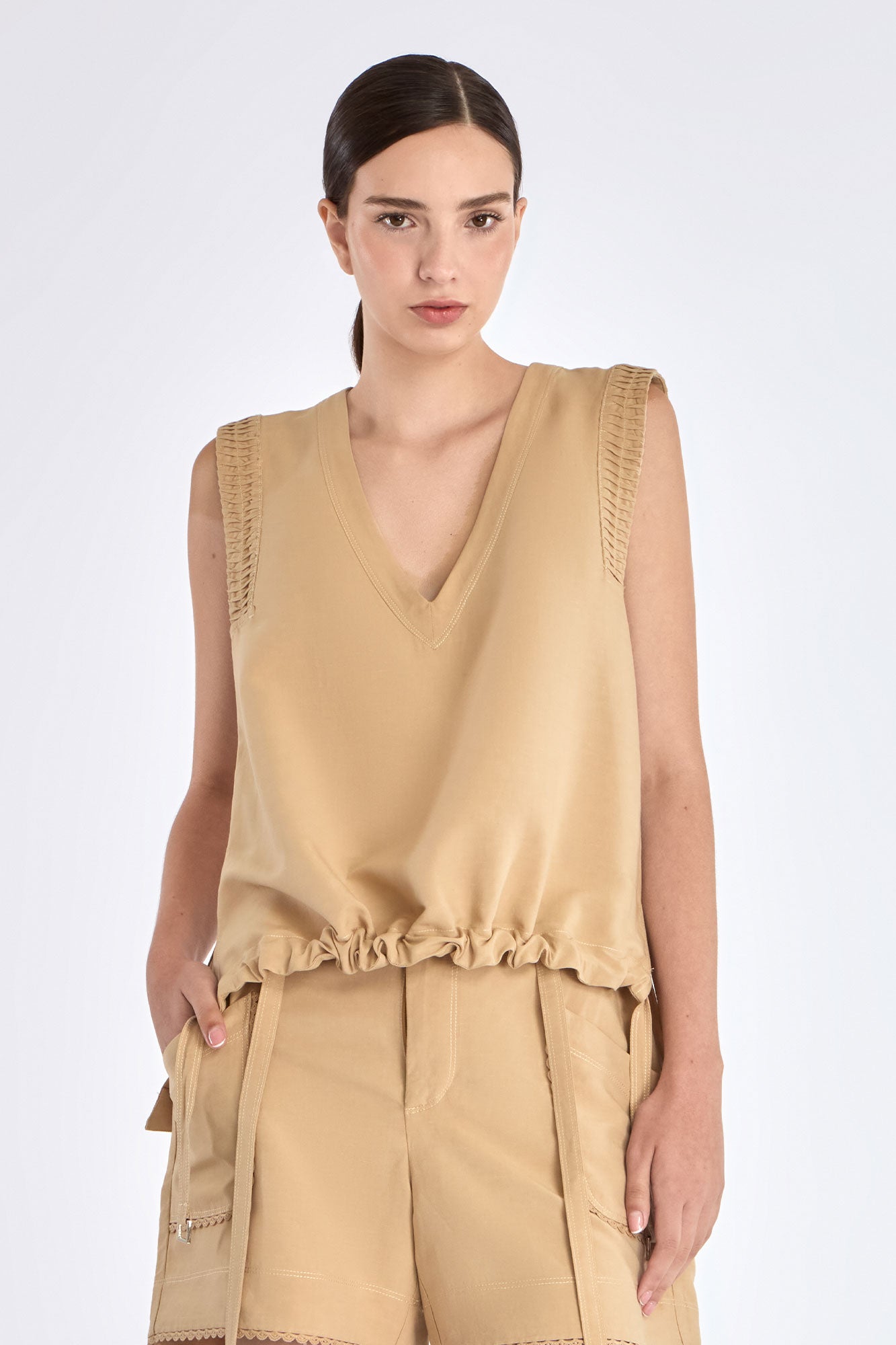 The Valencia Blouse in a rich Camel hue, showing its sleeveless design and premium linen blend.
