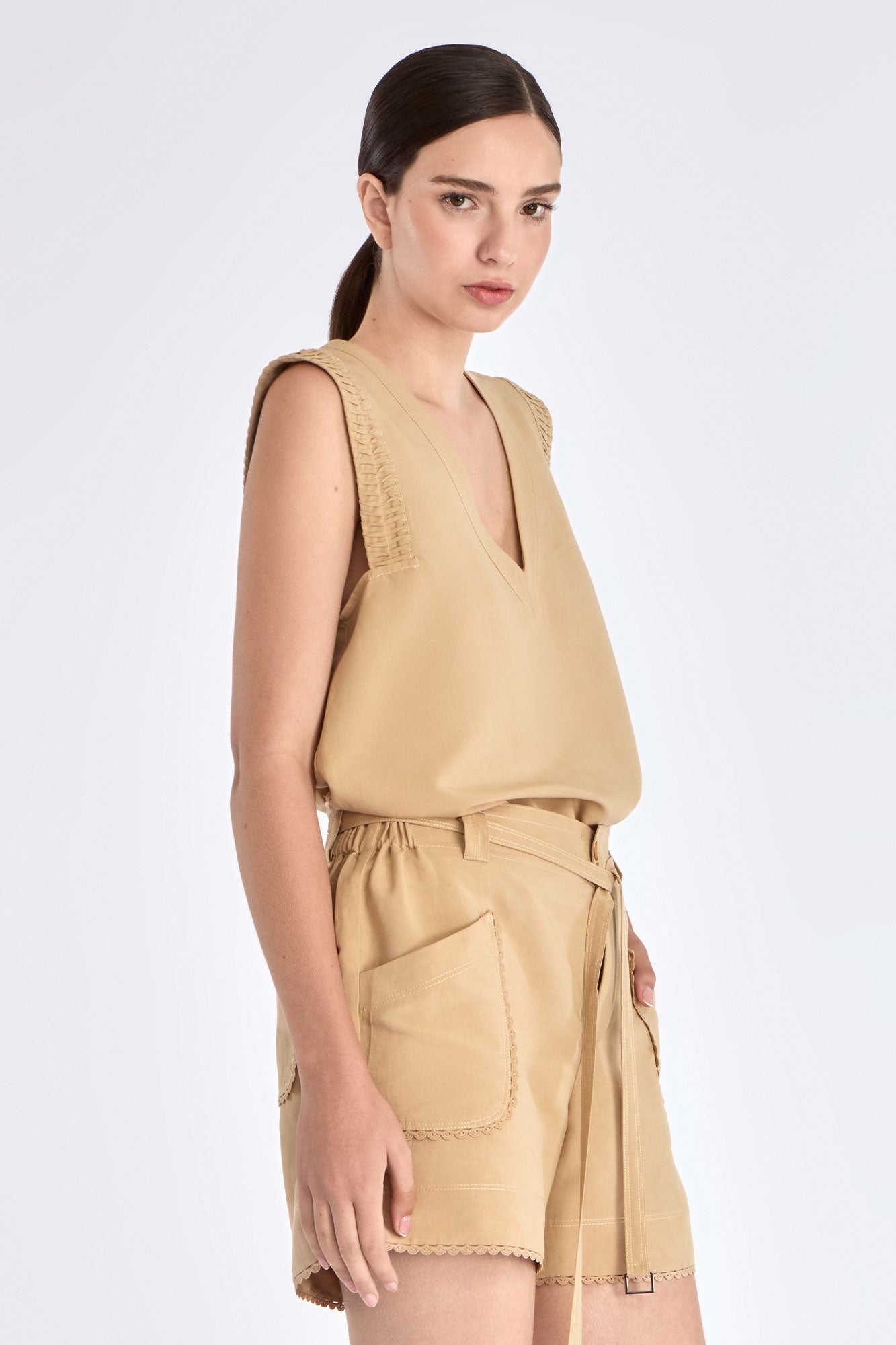 Side view of the Camel Valencia Blouse, with a focus on the adjustable buckle at the hem.