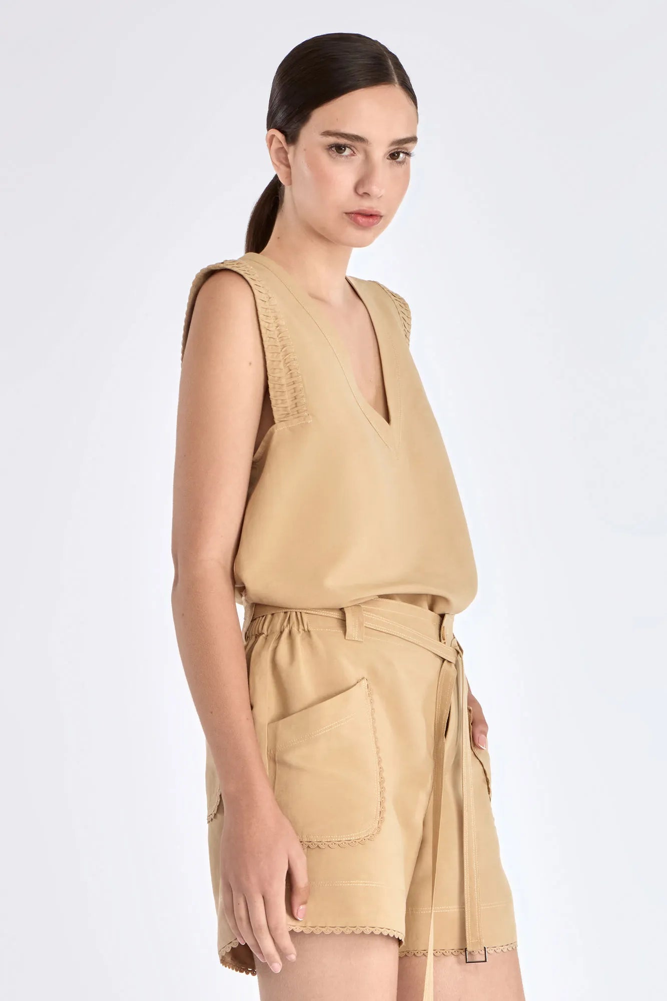 Side view of the Camel Valencia Blouse, with a focus on the adjustable buckle at the hem.