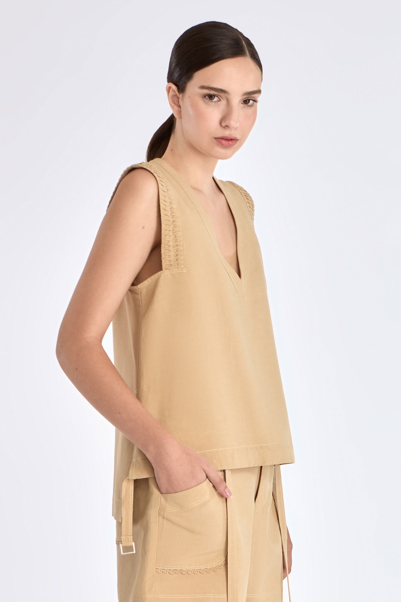 Side view of the Camel Valencia Blouse, with a focus on the adjustable buckle at the hem.