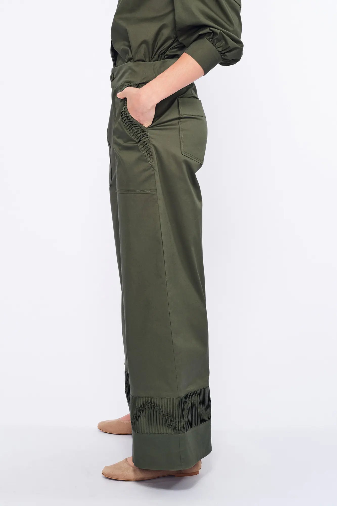 Side profile of the Olive Viena Trouser, highlighting the sculptural detail on the side pocket and hem.