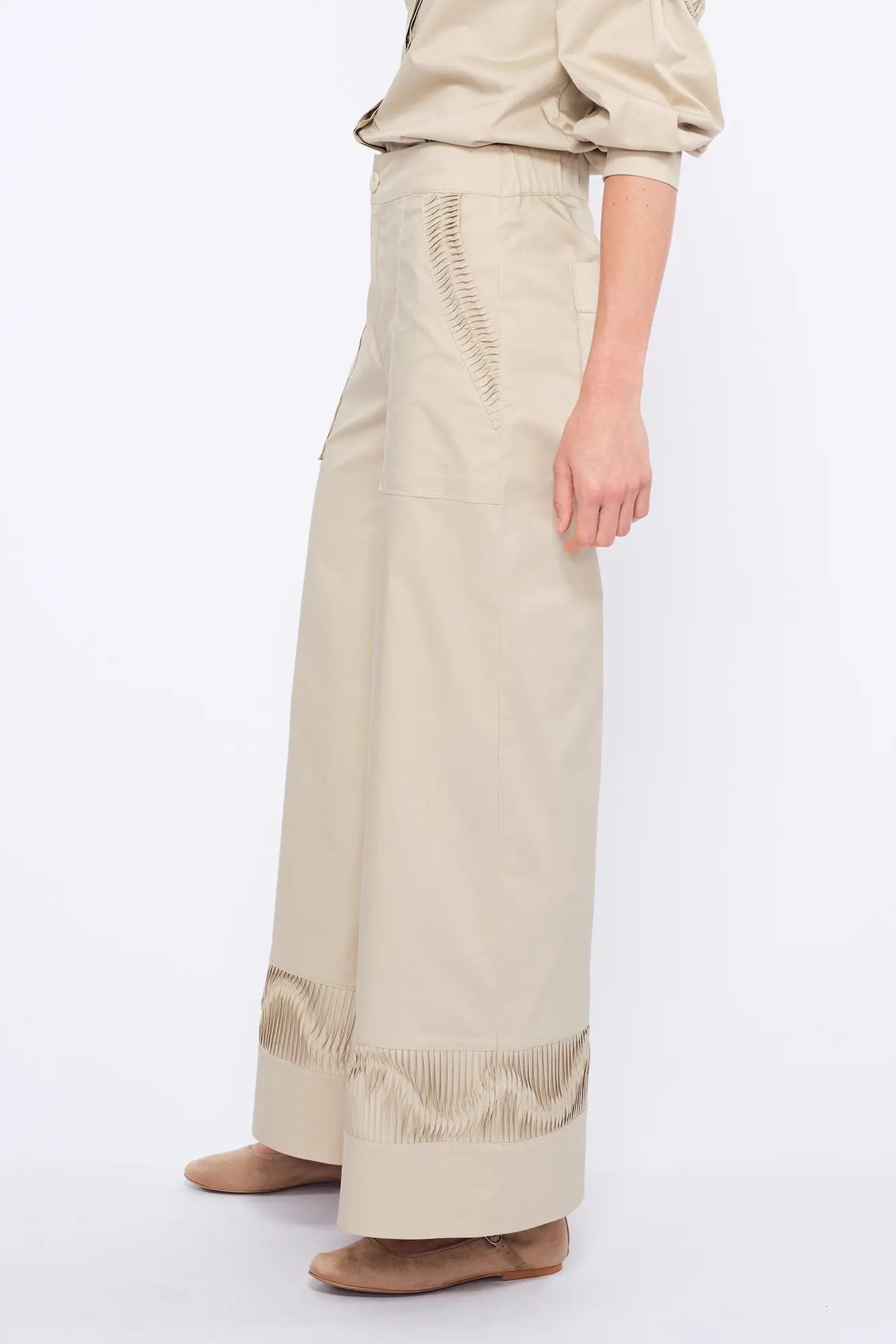 Side profile of the Pristine Viena Trouser, showcasing the unique raised embellishment on the pocket and hem.