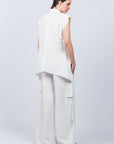 Zayla Blouse in Off White, elegant sleeveless blouse with an asymmetrical hem and shirt collar.