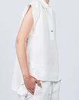 Zayla Blouse in Off White, elegant sleeveless blouse with an asymmetrical hem and shirt collar.