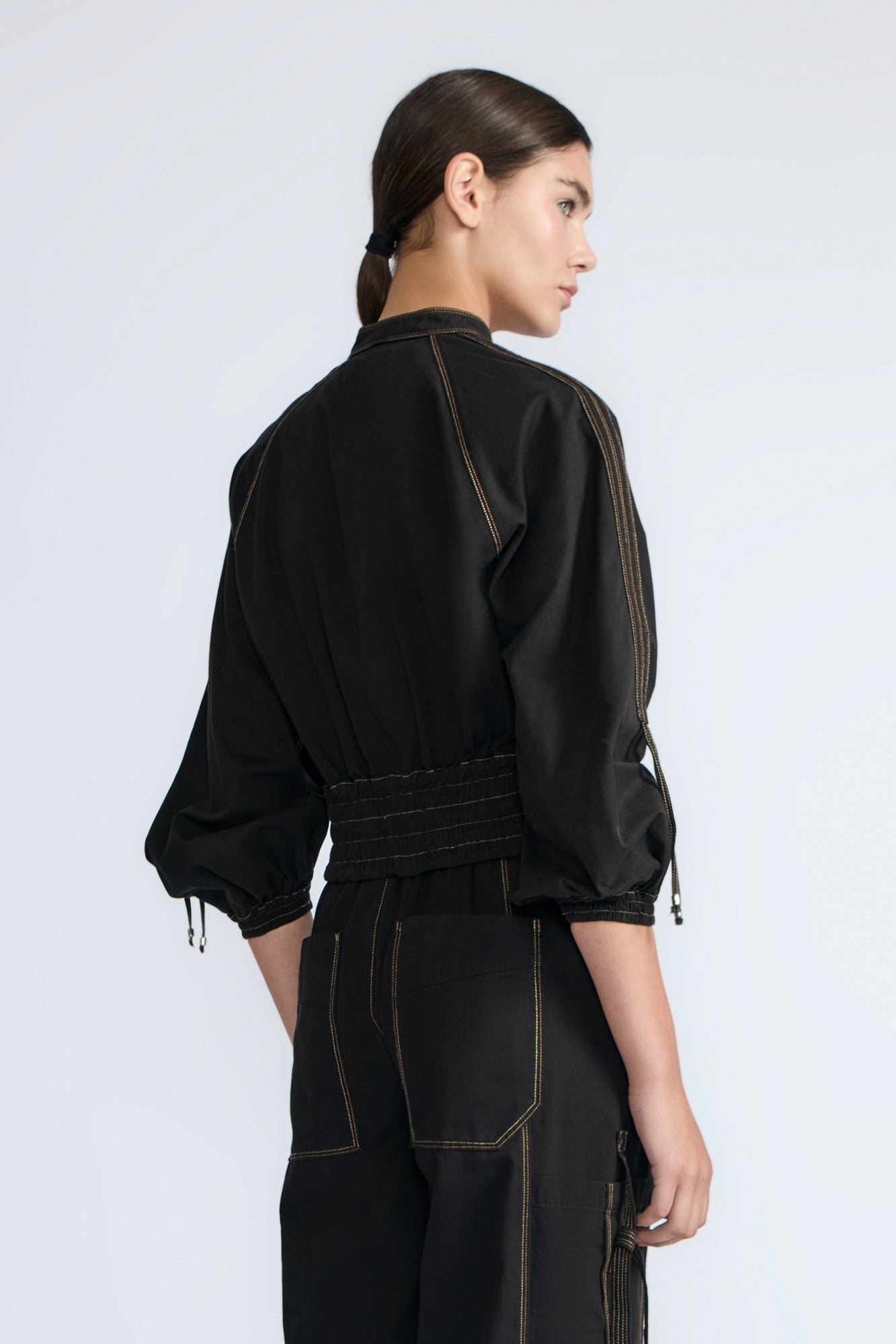 Zoe Jacket in Black – 100% cotton jacket with flap patch pockets, hidden buttons, long sleeves, and an adjustable drawstring hem.