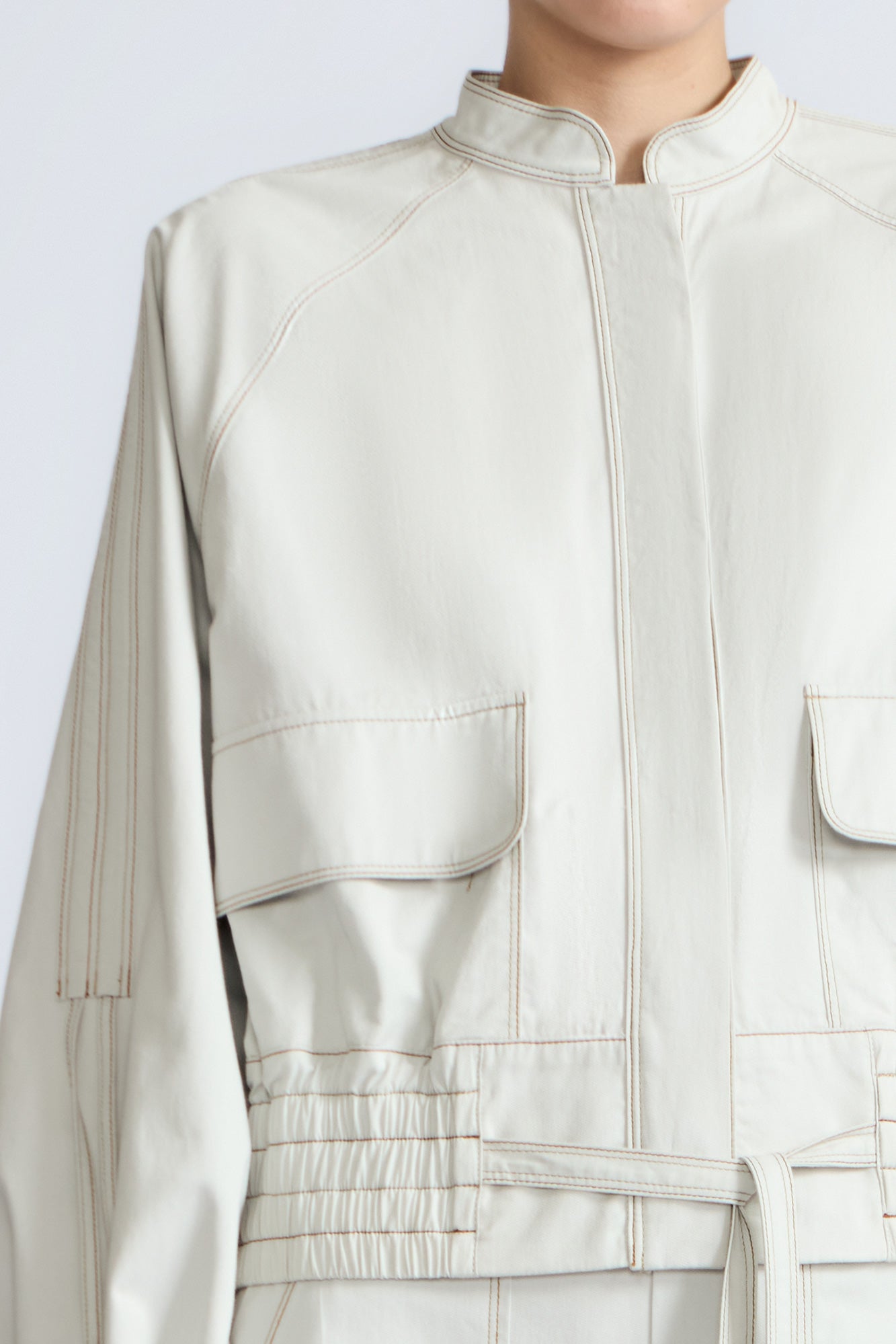 Zoe Jacket in Silver – 100% cotton jacket with flap patch pockets, hidden buttons, long sleeves, and an adjustable drawstring hem.