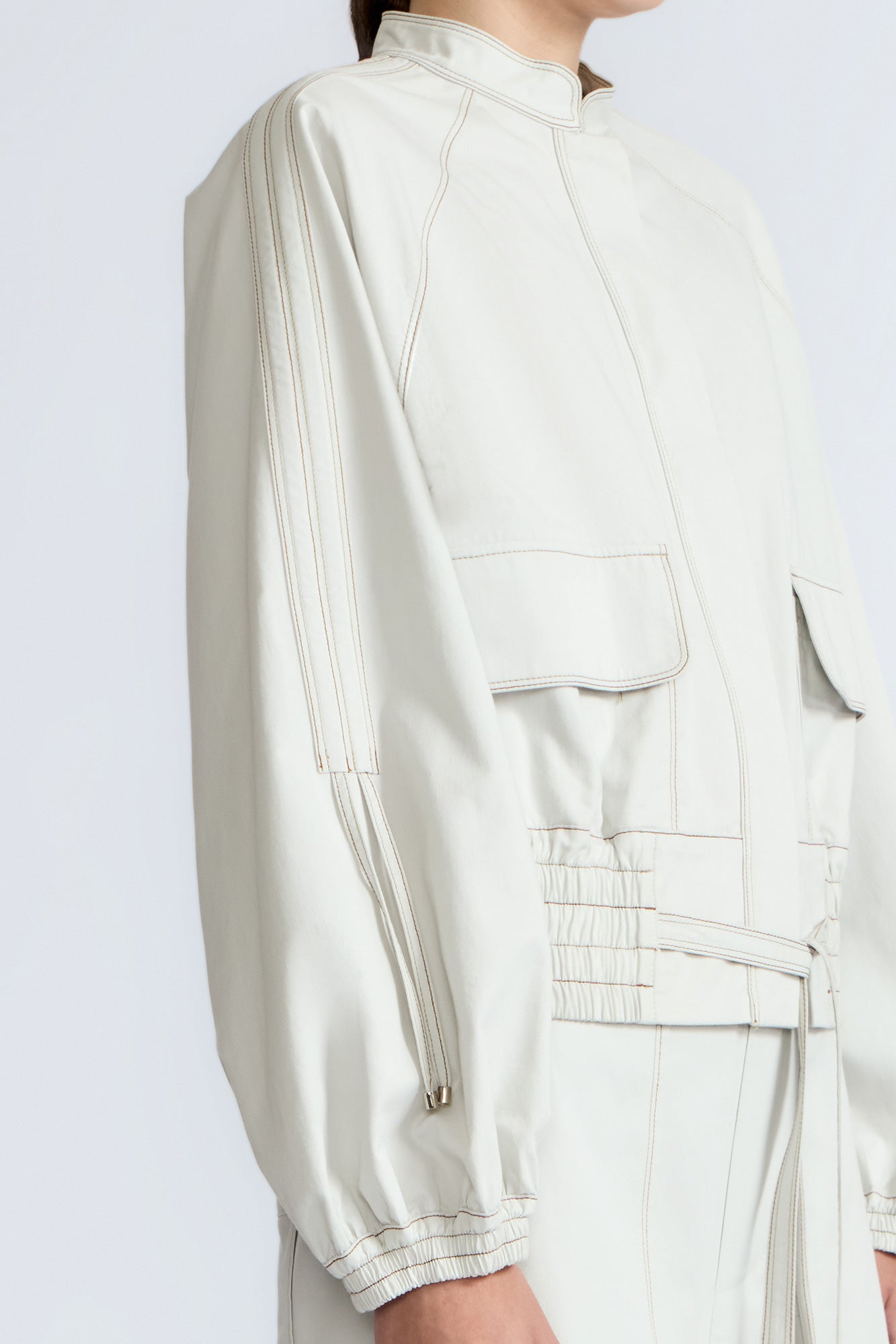 Zoe Jacket in Silver – 100% cotton jacket with flap patch pockets, hidden buttons, long sleeves, and an adjustable drawstring hem.
