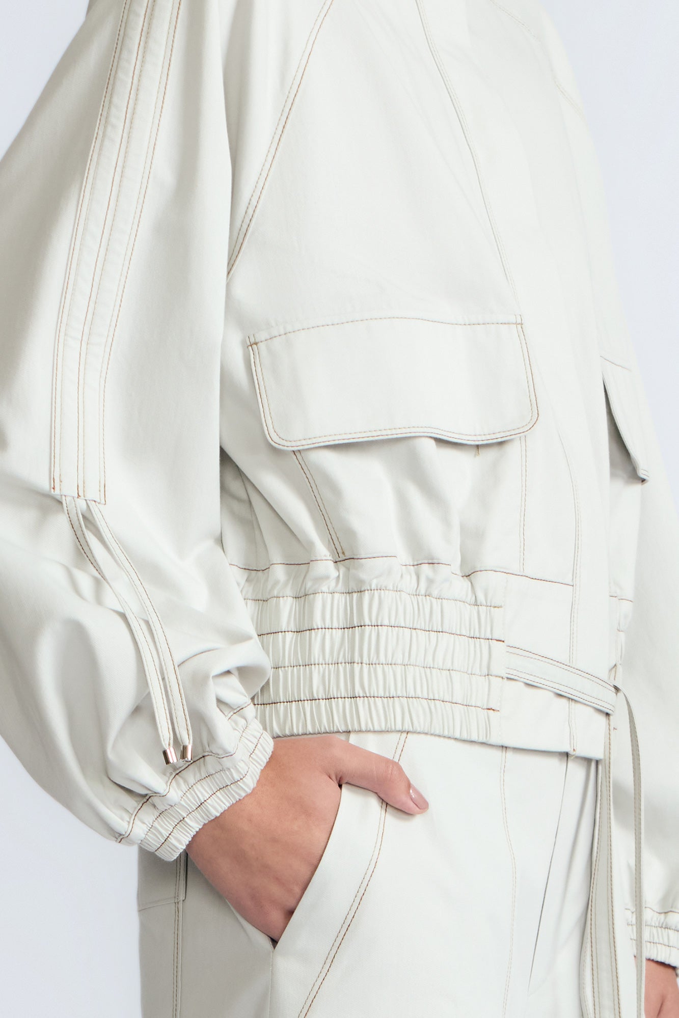 Zoe Jacket in Silver – 100% cotton jacket with flap patch pockets, hidden buttons, long sleeves, and an adjustable drawstring hem.