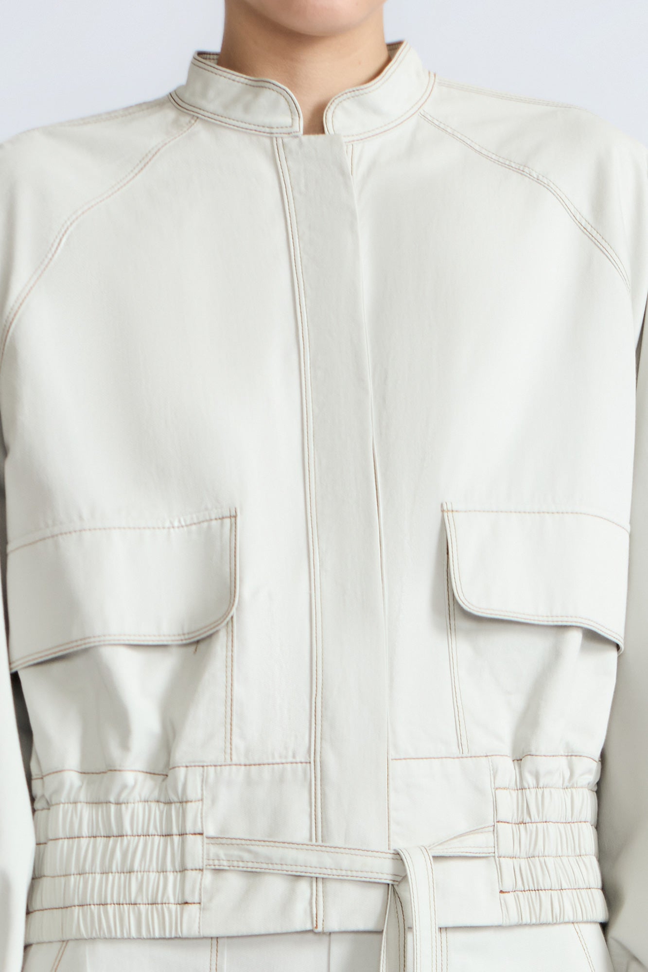 Zoe Jacket in Silver – 100% cotton jacket with flap patch pockets, hidden buttons, long sleeves, and an adjustable drawstring hem.