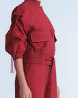 Red outfit with a high collar and puff sleeves on a light blue background